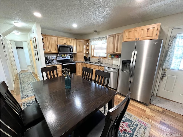 dining area featuring recessed lighting, light wood-style flooring, and a textured ceiling