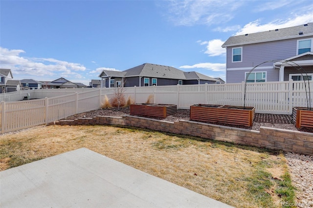 view of yard with a garden, a residential view, a patio, and fence