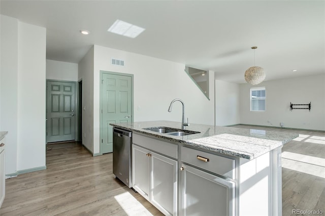 kitchen featuring visible vents, light stone countertops, dishwasher, light wood-style floors, and a sink