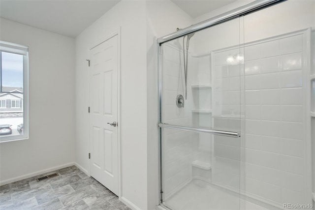 full bathroom with a shower stall, baseboards, and visible vents