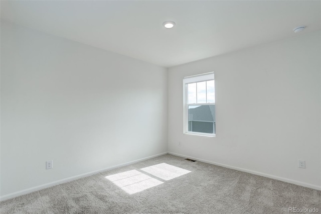 carpeted empty room featuring visible vents and baseboards