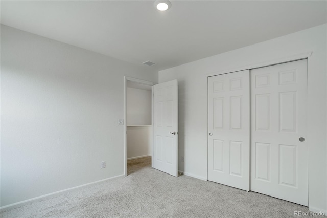 unfurnished bedroom with a closet, baseboards, and carpet flooring