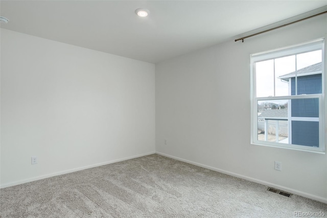 carpeted spare room with baseboards and visible vents