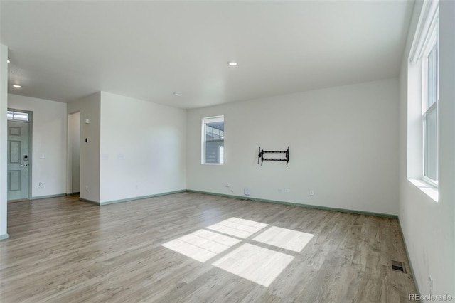 unfurnished room with recessed lighting, light wood-style floors, visible vents, and baseboards