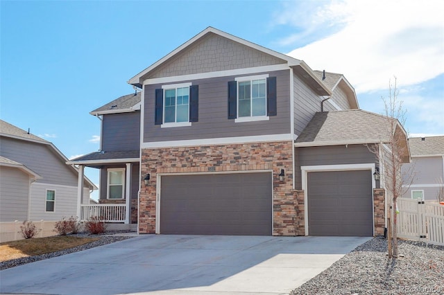 craftsman inspired home with an attached garage, a shingled roof, fence, stone siding, and driveway