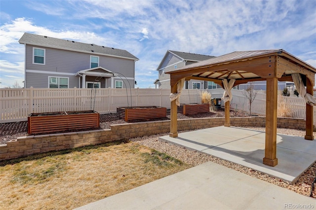 exterior space with a gazebo, a fenced backyard, and a garden