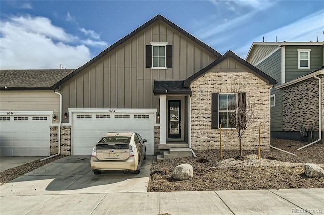 view of front of house with board and batten siding, concrete driveway, a shingled roof, a garage, and brick siding