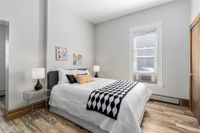813 E 14th Ave Unit 4, Denver, CO 80218 - bedroom featuring a baseboard heating unit and wood finished floors