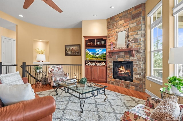 7003 S Irvington Ct, Aurora, CO 80016 - living room featuring wood finished floors, a stone fireplace, and ceiling fan