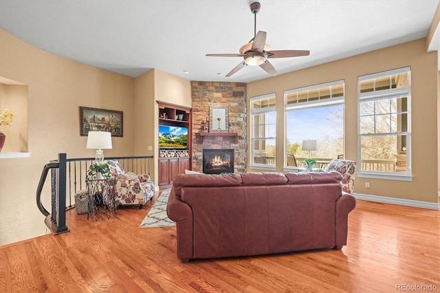 7003 S Irvington Ct, Aurora, CO 80016 - living room with a ceiling fan, plenty of natural light, light wood-style floors, and a stone fireplace