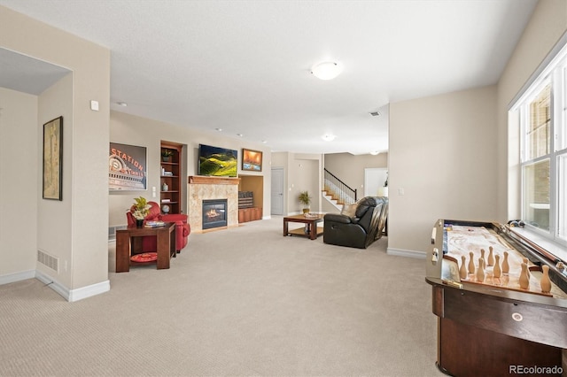 7003 S Irvington Ct, Aurora, CO 80016 - living area with stairway, carpet, a tiled fireplace, and built in shelves