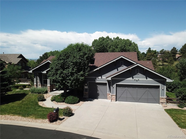 7003 S Irvington Ct, Aurora, CO 80016 - craftsman house featuring a garage, concrete driveway, stone siding, and roof with shingles
