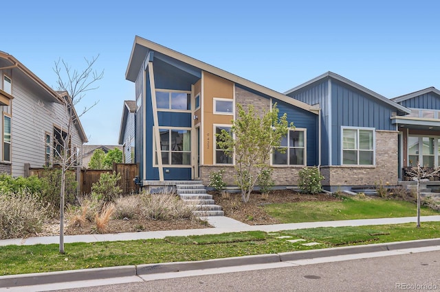view of front of house featuring board and batten siding and fence