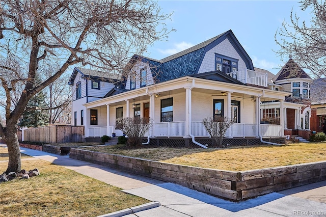 view of front of property featuring a front lawn, fence, a gambrel roof, a porch, and a balcony