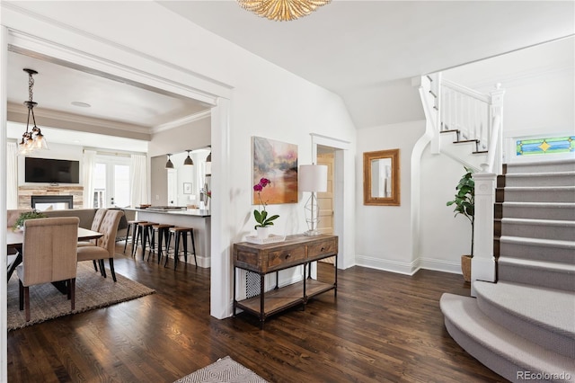 entrance foyer featuring dark wood-style floors, stairs, baseboards, and ornamental molding