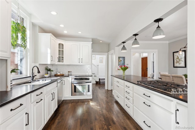 kitchen featuring dark countertops, appliances with stainless steel finishes, and a sink