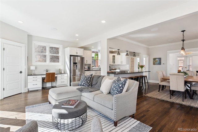 living area with dark wood-type flooring, recessed lighting, crown molding, baseboards, and built in study area