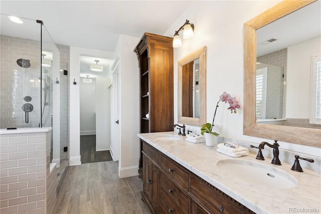 full bathroom with a sink, visible vents, a stall shower, and double vanity