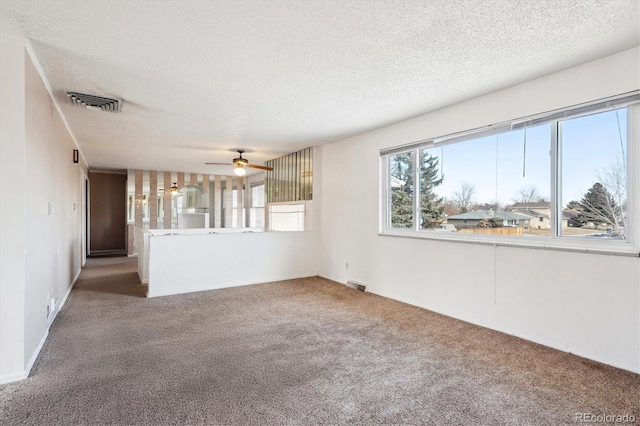 unfurnished living room with ceiling fan, a textured ceiling, and carpet