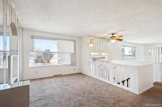 unfurnished living room with carpet floors and a textured ceiling