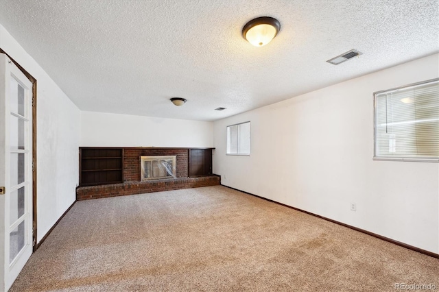 unfurnished living room featuring carpet flooring, a textured ceiling, and a fireplace