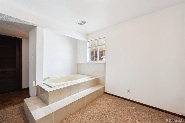 bathroom with a relaxing tiled tub