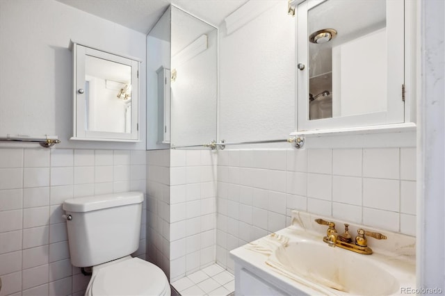 bathroom featuring vanity, toilet, and tile walls