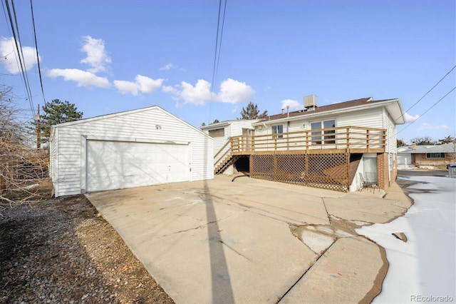 exterior space featuring a garage, central AC, an outdoor structure, and a deck