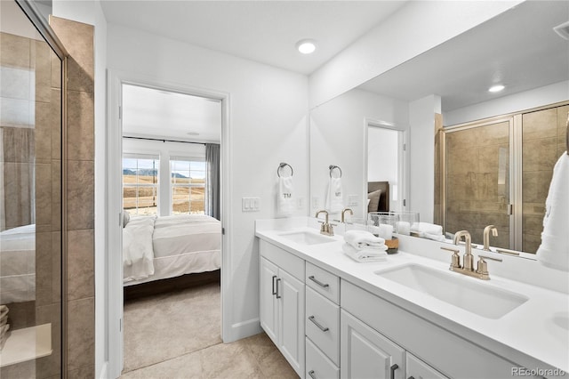 ensuite bathroom featuring double vanity, a sink, ensuite bath, and a stall shower