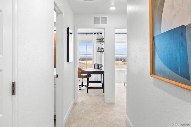 hallway featuring baseboards, carpet flooring, and visible vents