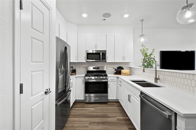kitchen featuring white cabinets, a sink, light countertops, stainless steel appliances, and tasteful backsplash