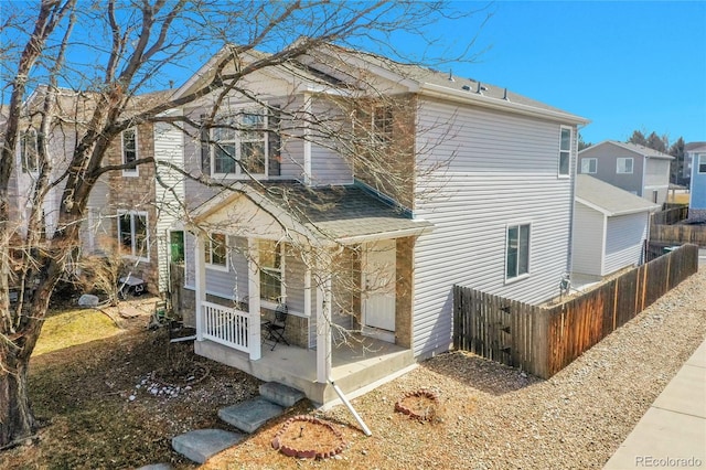 exterior space featuring covered porch and fence