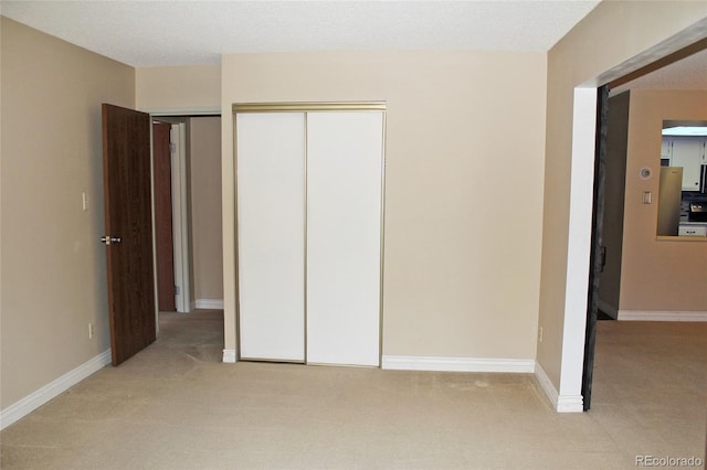 unfurnished bedroom with baseboards and light colored carpet