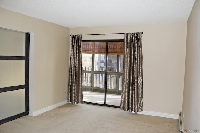 empty room featuring a baseboard heating unit, a textured ceiling, baseboards, and carpet flooring