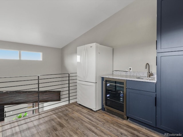436 N Fuller Placer Rd, Breckenridge, CO 80424 - bar area featuring wine cooler, freestanding refrigerator, vaulted ceiling, a sink, and wood finished floors