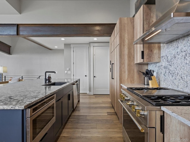 436 N Fuller Placer Rd, Breckenridge, CO 80424 - kitchen featuring appliances with stainless steel finishes, a sink, wall chimney exhaust hood, wood finished floors, and light stone counters