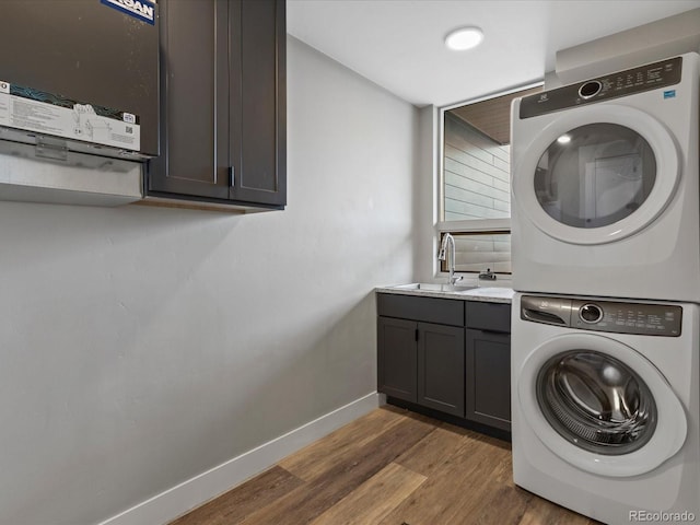 436 N Fuller Placer Rd, Breckenridge, CO 80424 - laundry area featuring stacked washing machine and dryer, baseboards, cabinet space, and wood finished floors