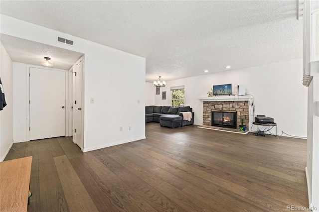 living area with a textured ceiling, a fireplace, a chandelier, dark wood-style flooring, and recessed lighting