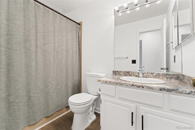 bathroom featuring toilet, wood finished floors, vanity, and a shower with curtain