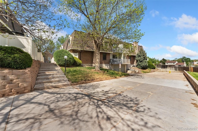 view of community featuring stairway, fence, and driveway