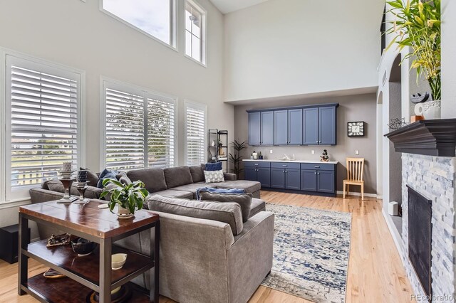 989 Graland Pl, Highlands Ranch, CO 80126 - living room with a high ceiling, light wood-type flooring, and a fireplace