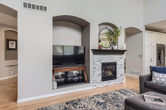 989 Graland Pl, Highlands Ranch, CO 80126 - living area featuring wood finished floors, a fireplace, baseboards, and arched walkways