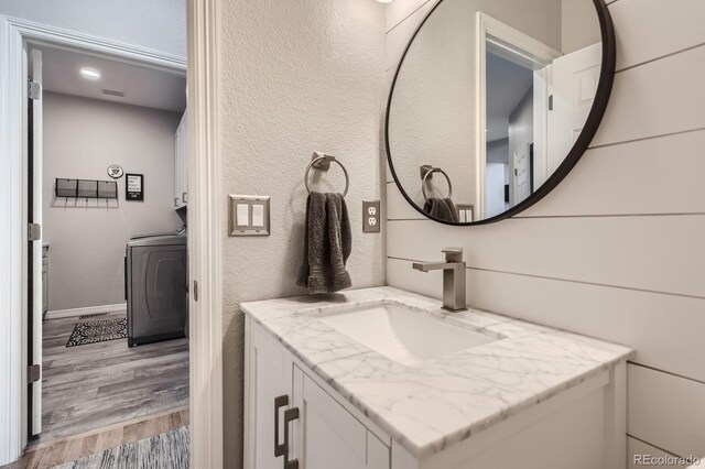 989 Graland Pl, Highlands Ranch, CO 80126 - bathroom with washer / dryer, wood finished floors, and vanity