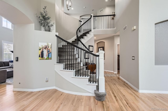 989 Graland Pl, Highlands Ranch, CO 80126 - stairway with arched walkways, a towering ceiling, wood finished floors, and plenty of natural light