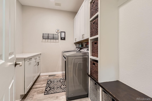 989 Graland Pl, Highlands Ranch, CO 80126 - laundry area featuring cabinet space, washing machine and clothes dryer, light wood-type flooring, and baseboards