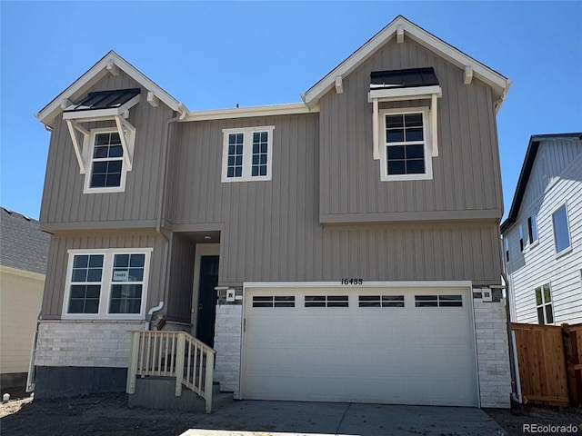 16488 W 92nd Pl, Arvada, CO 80007 - view of front of house featuring a garage, concrete driveway, and stone siding
