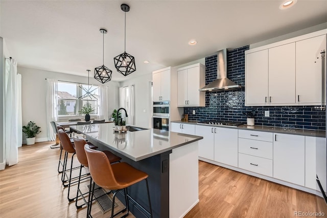 2840 E 102nd Pl, Thornton, CO 80229 - kitchen featuring a sink, wall chimney range hood, gas stovetop, tasteful backsplash, and stainless steel double oven