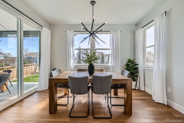 2840 E 102nd Pl, Thornton, CO 80229 - dining room with a chandelier, wood finished floors, and baseboards