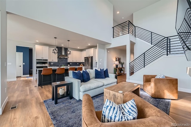 2840 E 102nd Pl, Thornton, CO 80229 - living area featuring light wood finished floors, stairway, recessed lighting, and a high ceiling