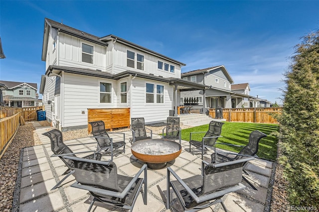 2840 E 102nd Pl, Thornton, CO 80229 - back of house featuring board and batten siding, a fenced backyard, a patio, and an outdoor fire pit